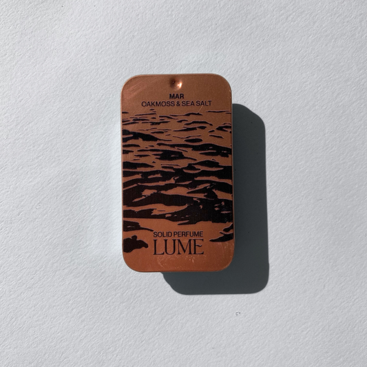Top view of a solid perfume in a metal tin.